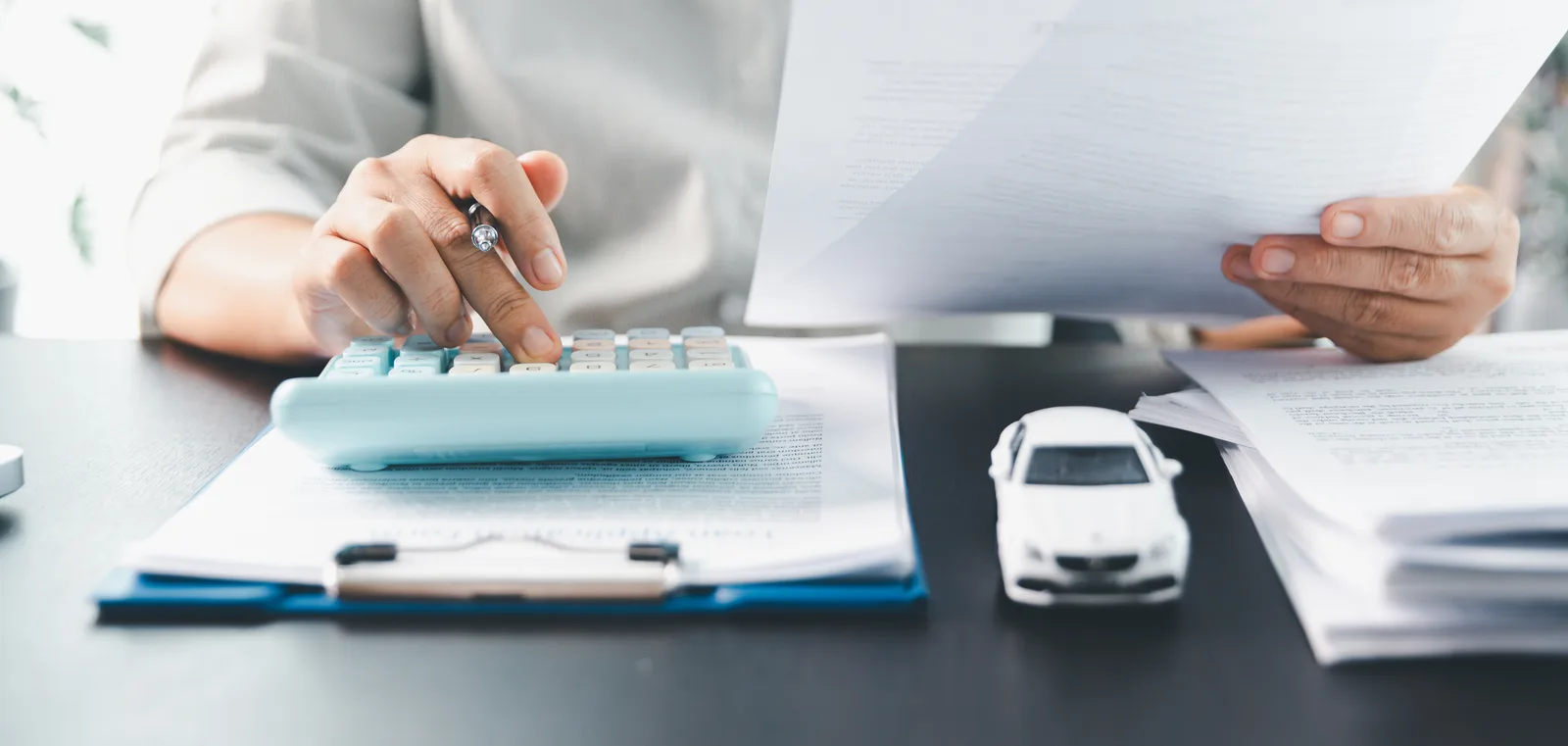 A person reviewing bills and insurance paperwork with a calculator